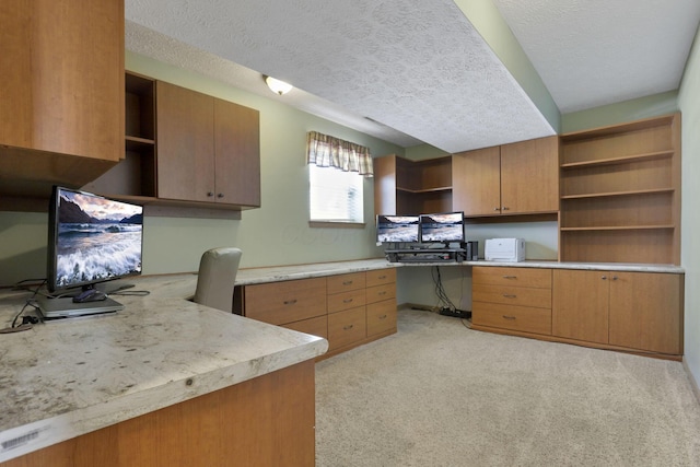 kitchen featuring brown cabinets, light countertops, built in desk, and open shelves