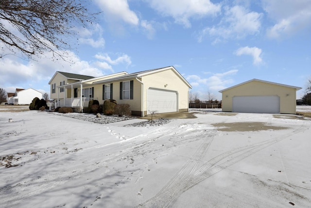 view of front of house with a detached garage and a porch