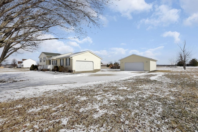 view of snowy exterior with a detached garage