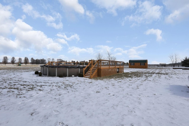 exterior space with a shed, a wooden deck, and an outdoor pool