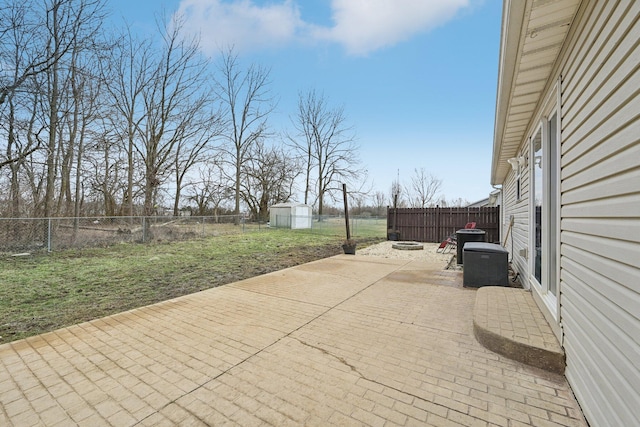 view of patio featuring a fenced backyard, an outdoor structure, and a storage shed