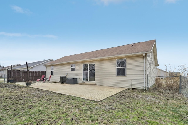 rear view of house featuring a patio, central AC, a fenced backyard, and a lawn