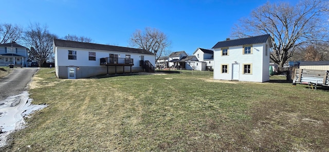 back of house with a wooden deck and a lawn