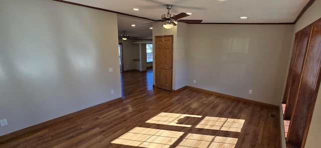 spare room with dark hardwood / wood-style flooring, ornamental molding, and ceiling fan