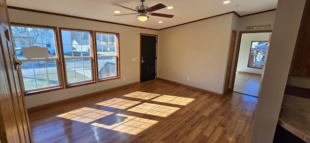 spare room featuring crown molding, ceiling fan, a healthy amount of sunlight, and dark hardwood / wood-style flooring