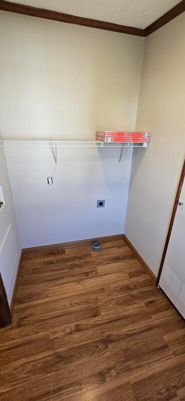 clothes washing area featuring electric dryer hookup, dark hardwood / wood-style flooring, and ornamental molding