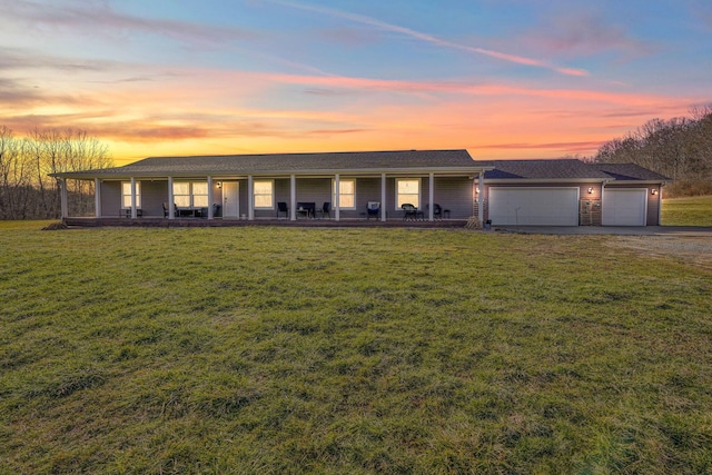 ranch-style house with a garage, a yard, and covered porch