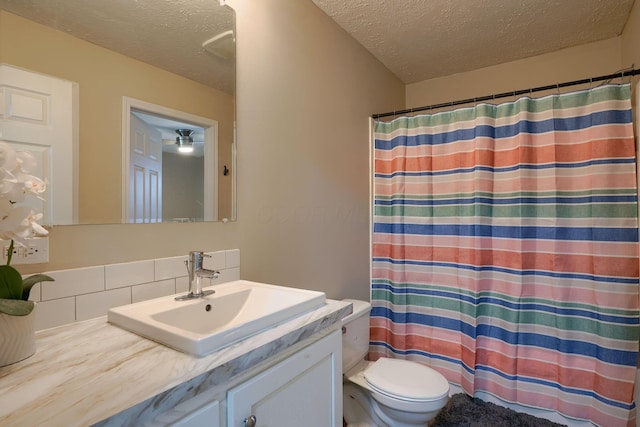 bathroom featuring vanity, a textured ceiling, and toilet