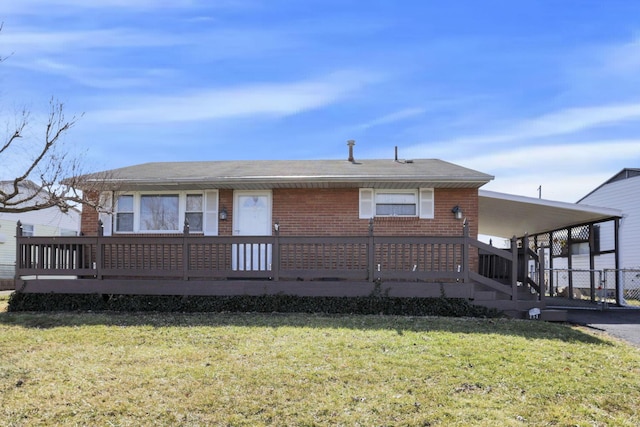 view of front of house with an attached carport, brick siding, driveway, stairway, and a front yard