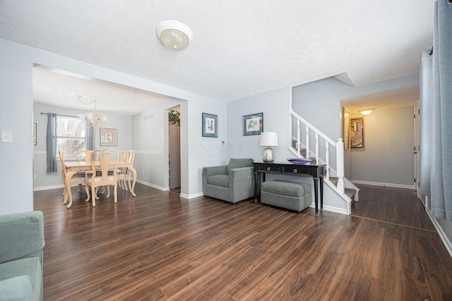 living area with dark wood-style floors, stairway, and a textured ceiling