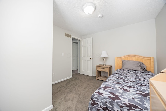 bedroom featuring light carpet, a textured ceiling, visible vents, and baseboards