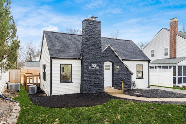 view of front of property with central AC unit and a front yard