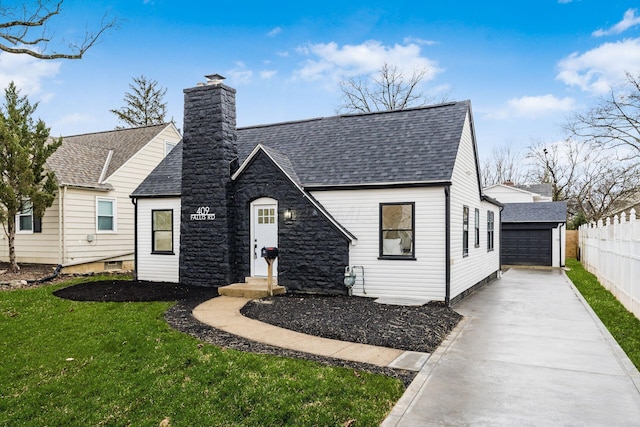 view of front of home with a garage, an outdoor structure, and a front lawn