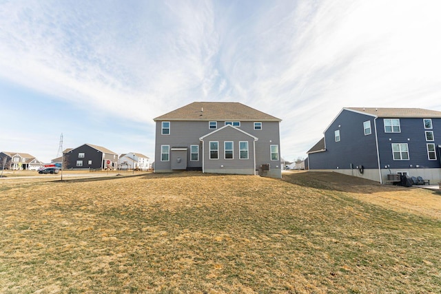 back of house with cooling unit and a yard