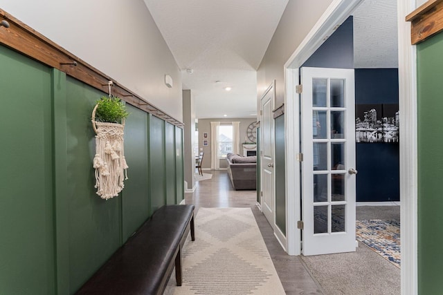 hall featuring light hardwood / wood-style floors and a textured ceiling