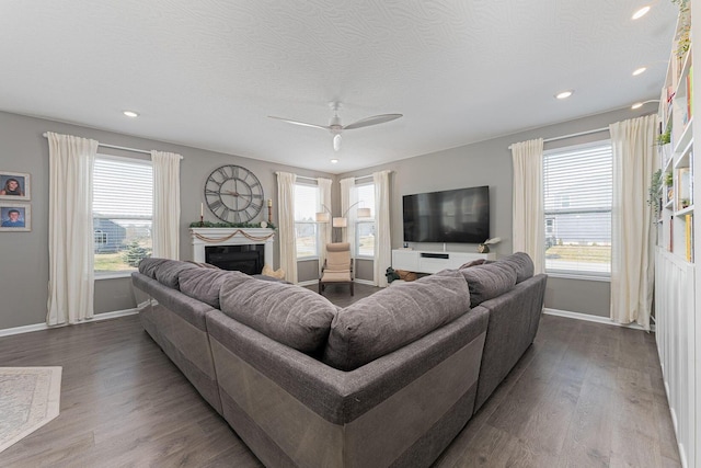 living room featuring ceiling fan, hardwood / wood-style floors, and a textured ceiling