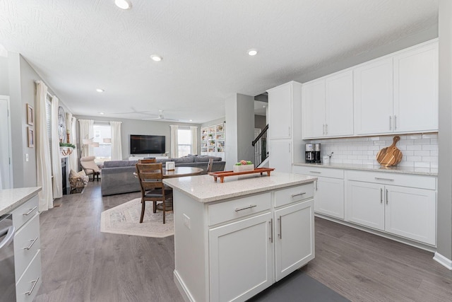 kitchen with white cabinetry, hardwood / wood-style floors, tasteful backsplash, and a center island