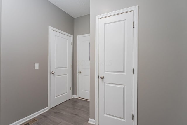 corridor featuring a textured ceiling and light hardwood / wood-style flooring