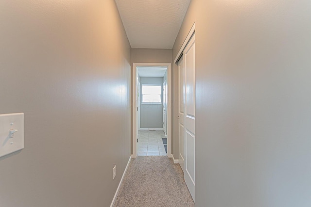 hall with light colored carpet