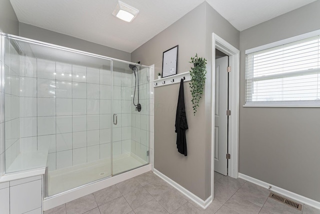 bathroom featuring tile patterned floors, a textured ceiling, and a shower with shower door