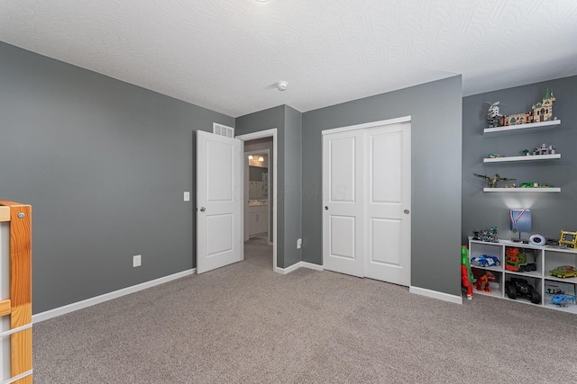 unfurnished bedroom featuring carpet flooring, a textured ceiling, and a closet