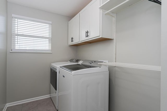 laundry area with separate washer and dryer, dark tile patterned flooring, and cabinets