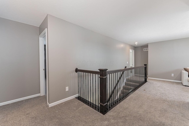 hallway featuring carpet floors and a textured ceiling