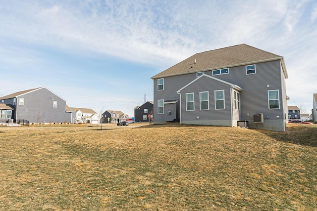 back of property featuring central AC and a yard