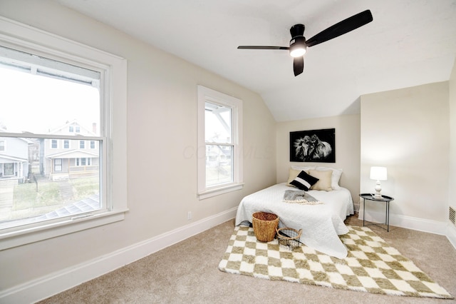 carpeted bedroom with ceiling fan and vaulted ceiling