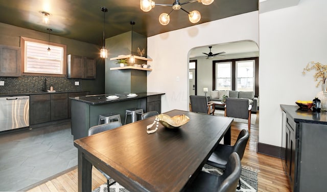 dining space featuring ceiling fan, sink, and light wood-type flooring