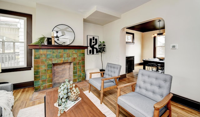 living room with an inviting chandelier, hardwood / wood-style floors, and a tile fireplace