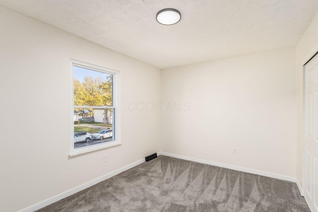 unfurnished room with carpet floors and a textured ceiling