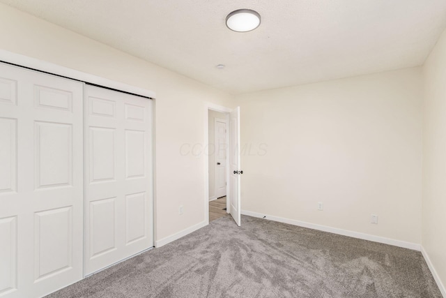 unfurnished bedroom with light carpet and a closet