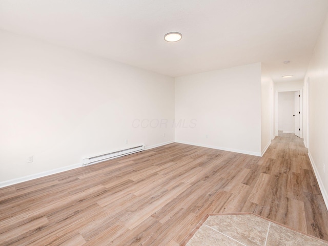 spare room with light hardwood / wood-style flooring and a baseboard heating unit