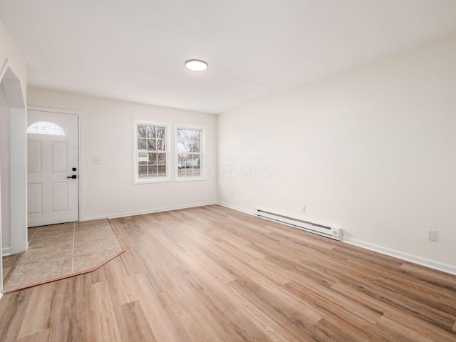 foyer entrance with light wood-type flooring and a baseboard heating unit