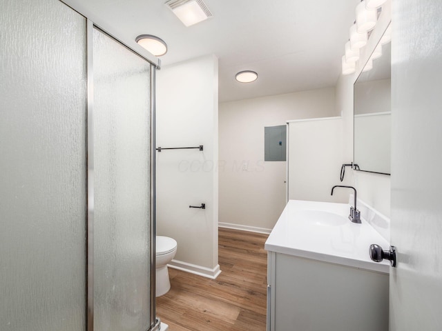 bathroom with hardwood / wood-style flooring, vanity, electric panel, and toilet