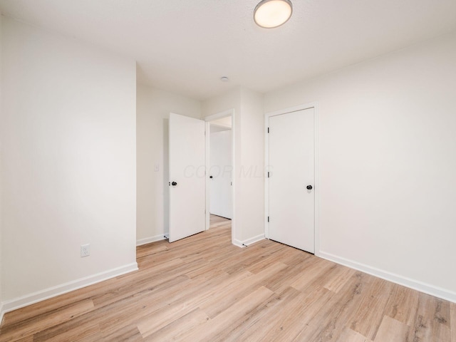 unfurnished bedroom with light hardwood / wood-style flooring and a closet