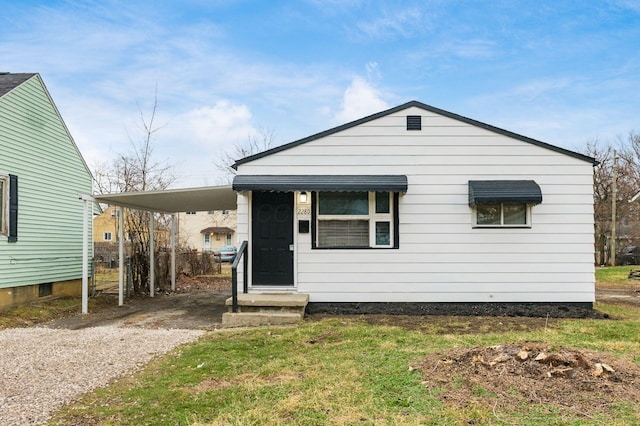 view of front of house with a carport and a front yard