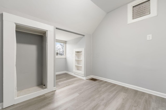 unfurnished bedroom with lofted ceiling, light hardwood / wood-style floors, and a closet