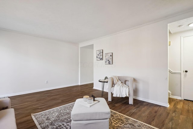 living area featuring ornamental molding, baseboards, and dark wood-type flooring