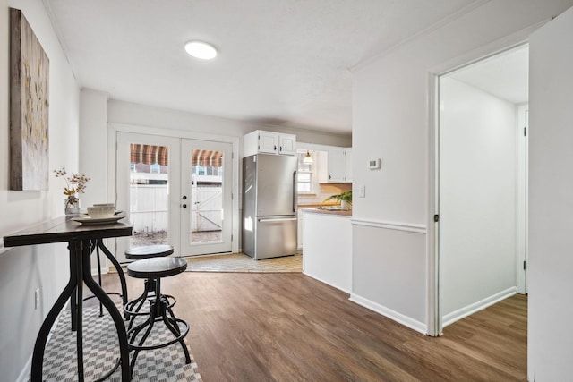 kitchen featuring french doors, freestanding refrigerator, dark wood-type flooring, light countertops, and white cabinetry