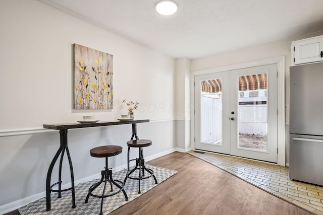 entryway featuring wood finished floors, baseboards, and french doors