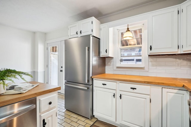 kitchen with stainless steel appliances, butcher block counters, and white cabinets