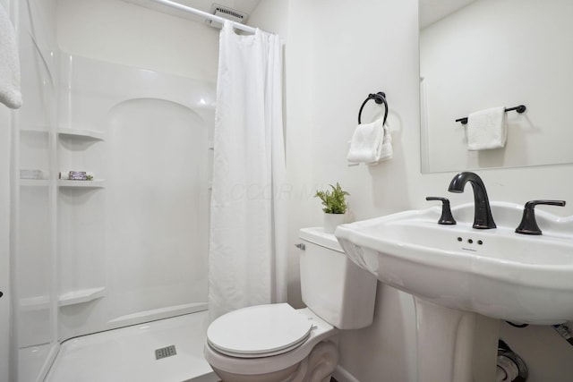 bathroom with toilet, a stall shower, and visible vents