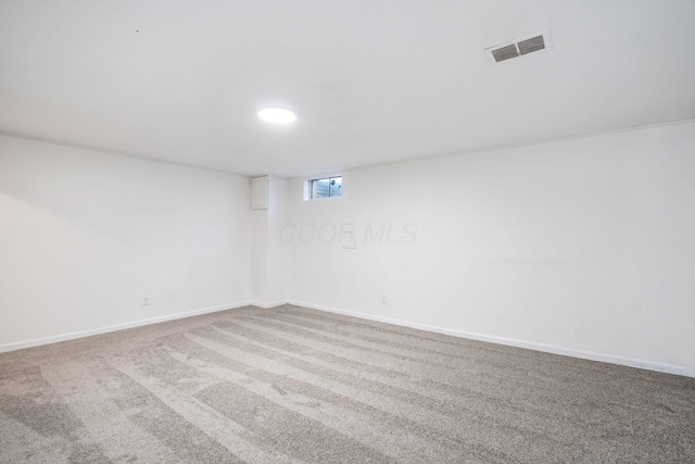 below grade area with carpet, baseboards, and visible vents