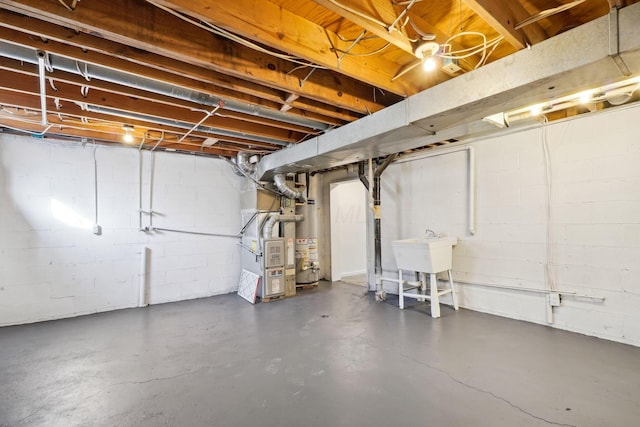 unfinished basement with gas water heater, heating unit, and a sink