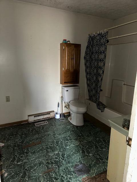 bathroom featuring shower / tub combo with curtain and toilet