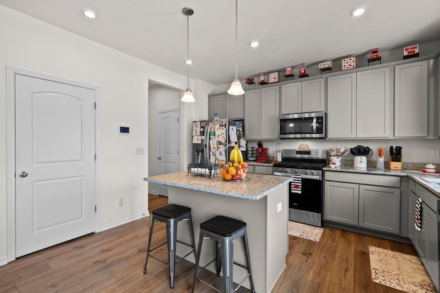 kitchen featuring stainless steel appliances, a center island, gray cabinetry, and pendant lighting