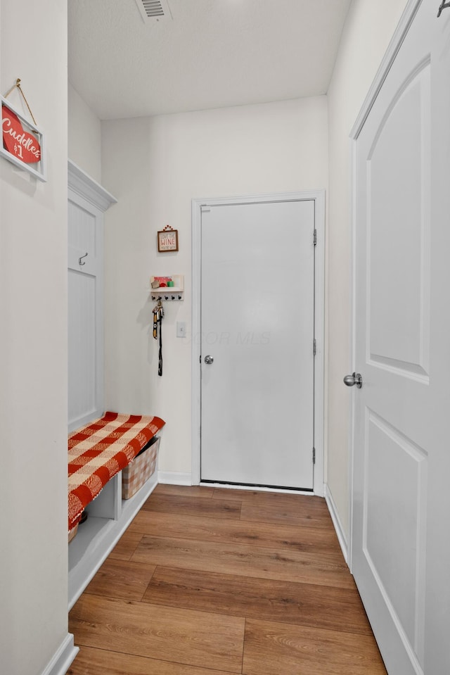 mudroom with wood finished floors and baseboards