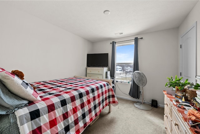 bedroom with baseboards, light colored carpet, a textured ceiling, and visible vents